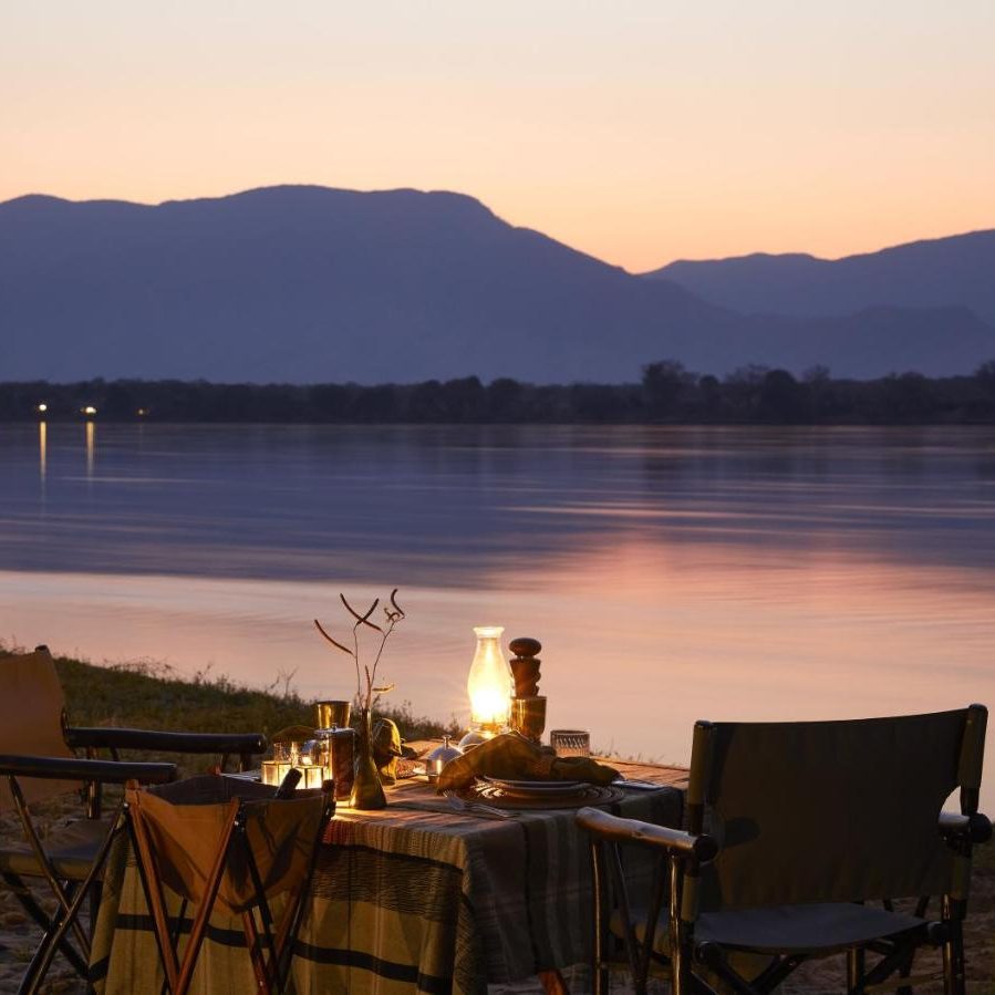 Budget-friendly romantic honeymoon setup by the Zambezi River with sunset views.