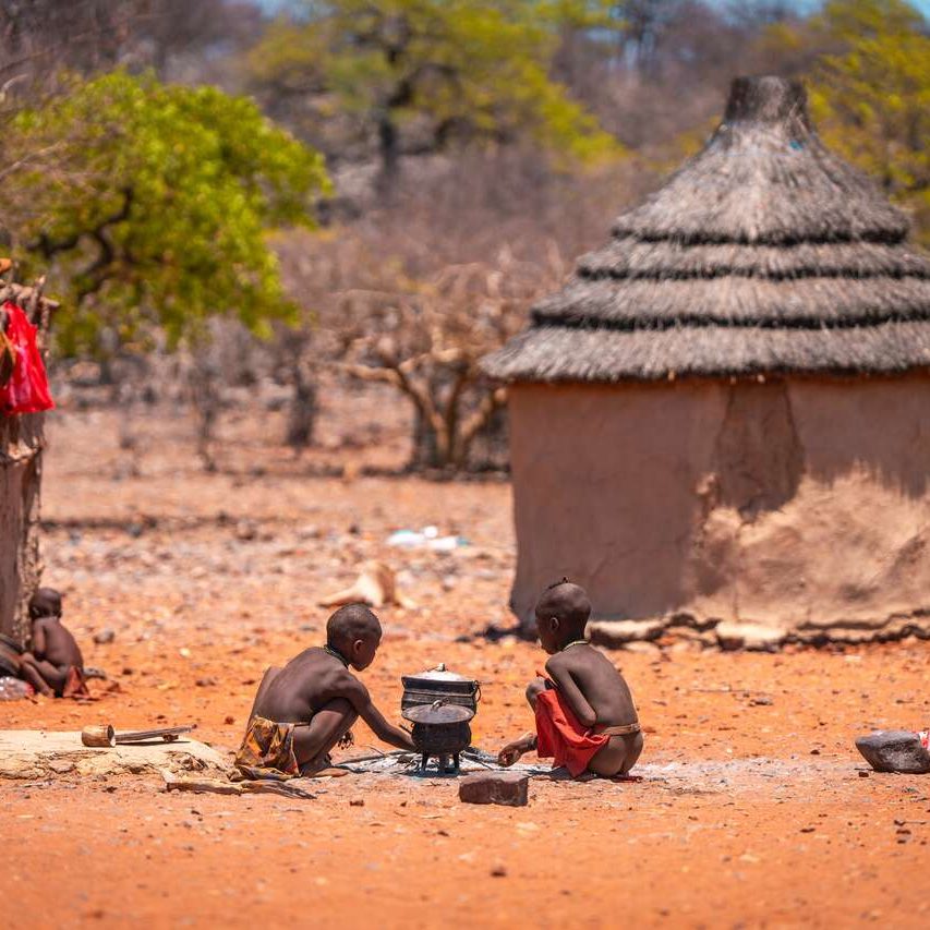 Himba children cooking outdoors in a traditional village in northern Namibia, cultural tour experience_Mtembezi African Safaris