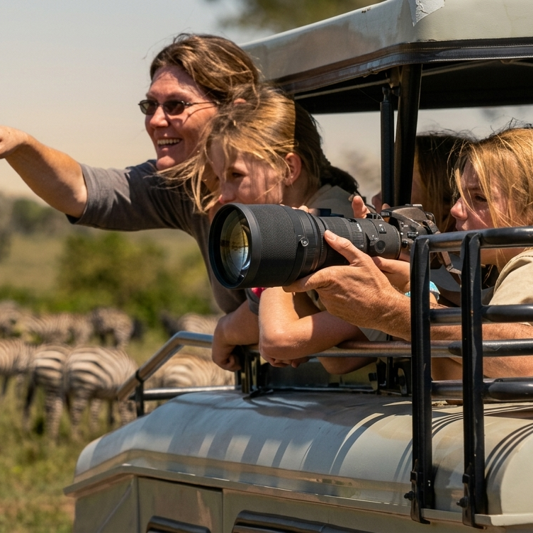Family enjoying a budget-friendly holiday with kids taking photos on a game drive_mtembezi african safaris